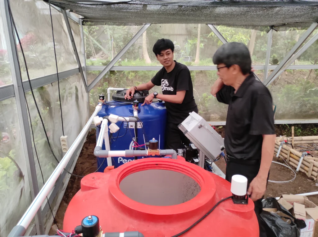 Tim MSMB melakukan instalasi dan commissioning sistem Amerta dengan tangki mixing dan panel kontrol di greenhouse hidroponik