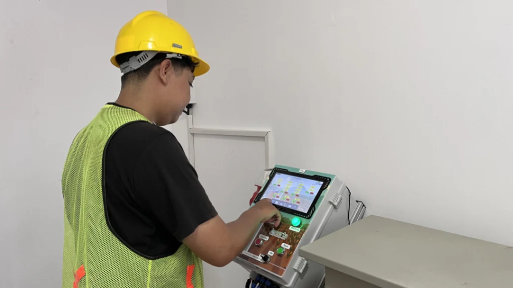 Teknisi MSMB mengoperasikan touchscreen panel kontrol Amerta untuk monitoring dan pengaturan irigasi fertigasi otomatis real-time